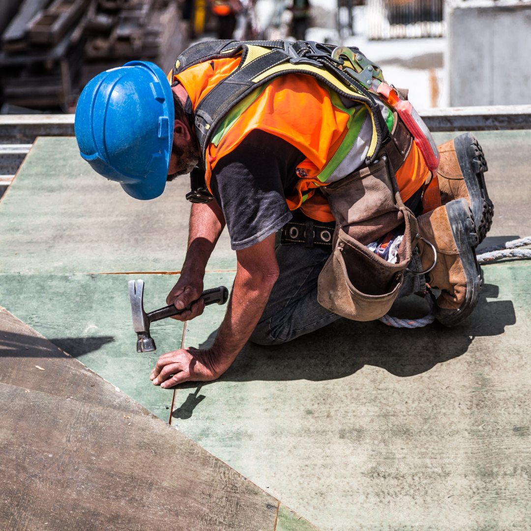 Trabajador de construcción con casco azul trabajando en el suelo